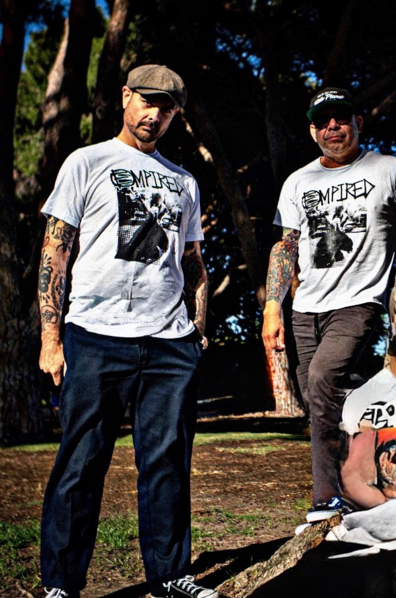 Two band members wearing matching white custom screen-printed Empired band t-shirts printed by CC Print