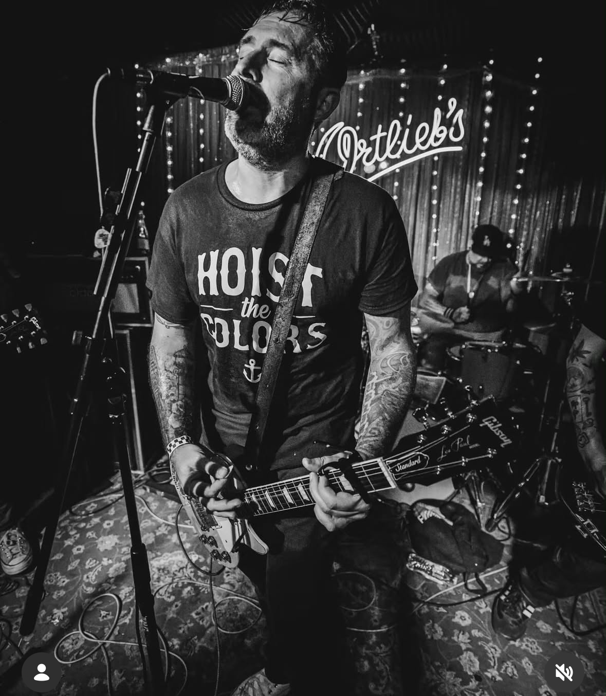 Band performing on stage in a custom-printed CC Print band t-shirt