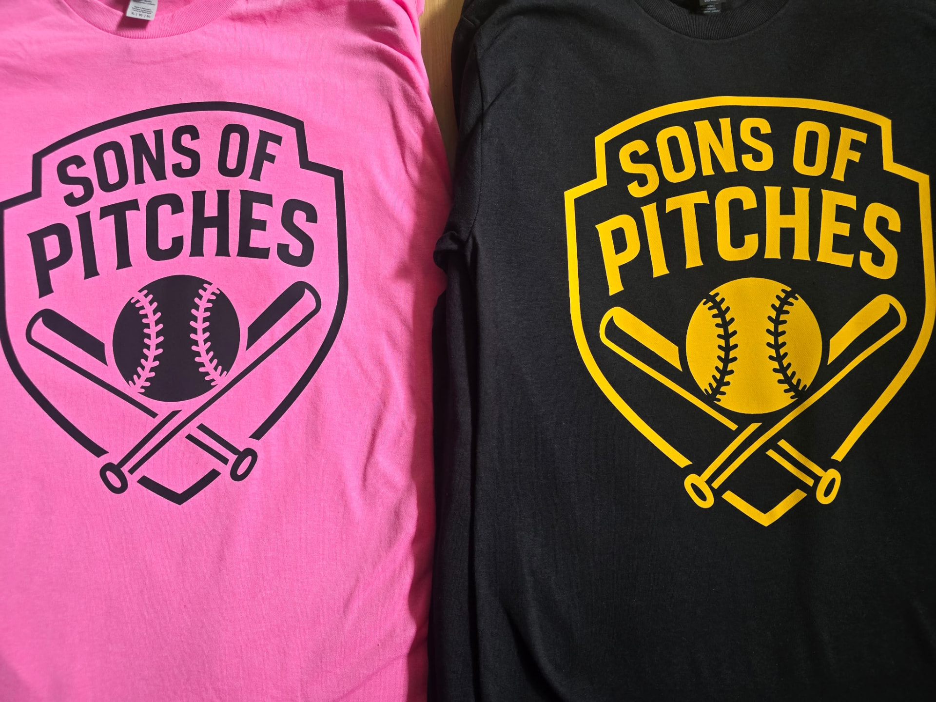 Two screen-printed softball team t-shirts in pink and black printed by CC Print