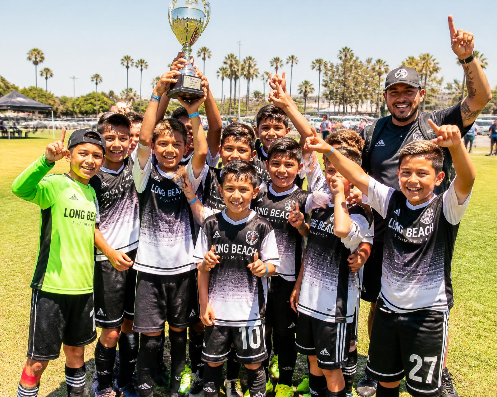 Long Beach youth soccer team holding a trophy in custom CC Print jerseys